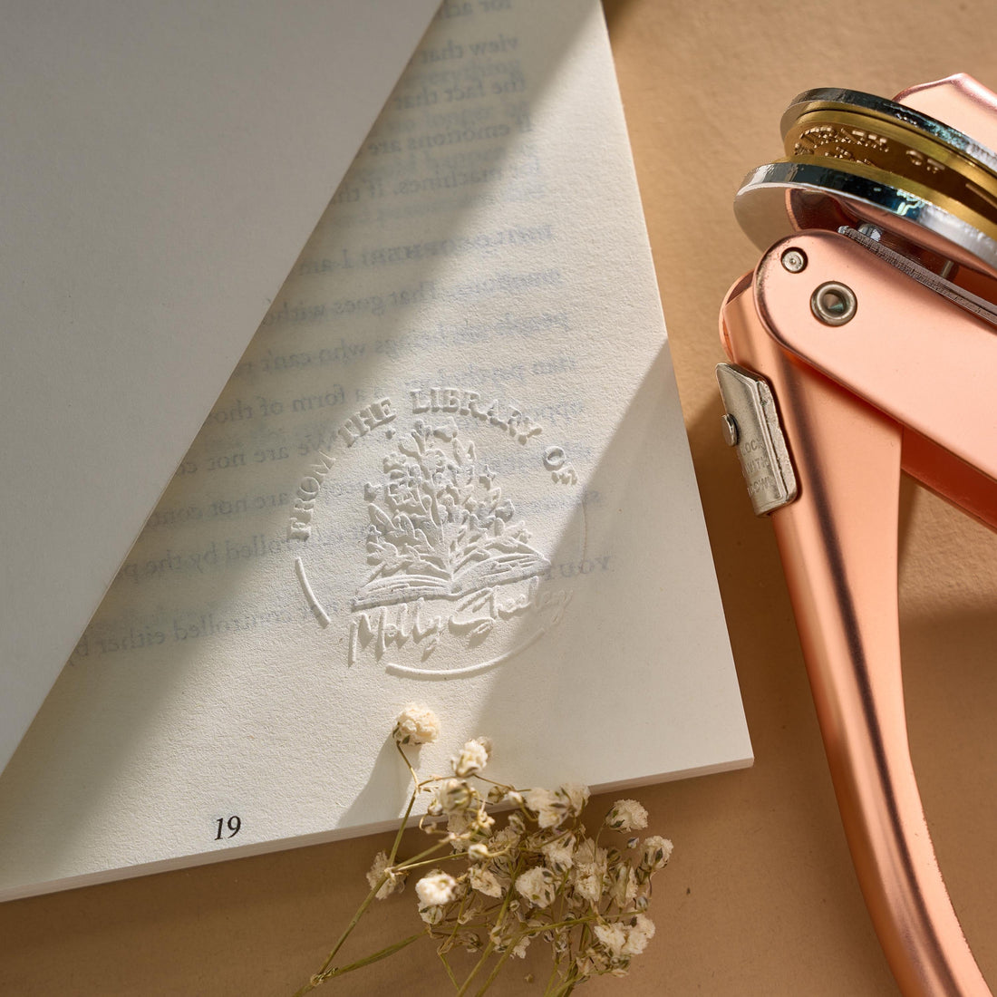 Custom book embosser creating elegant raised impression on book title page